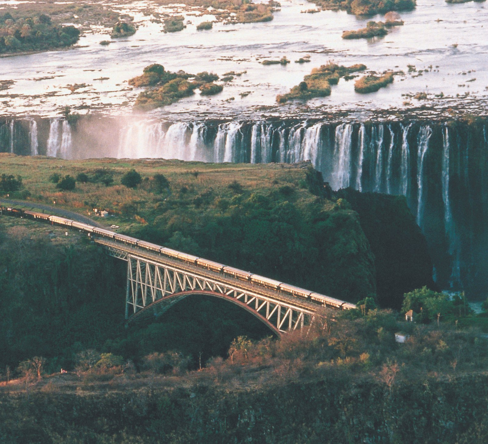 Victoria Falls Brücke mit Wasserfällen im Hintergrund