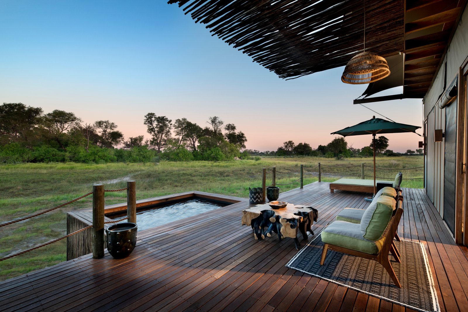 Zimmerterrasse mit Sitzgelegenheit und privaten Plungepool mit Sicht zum Busch