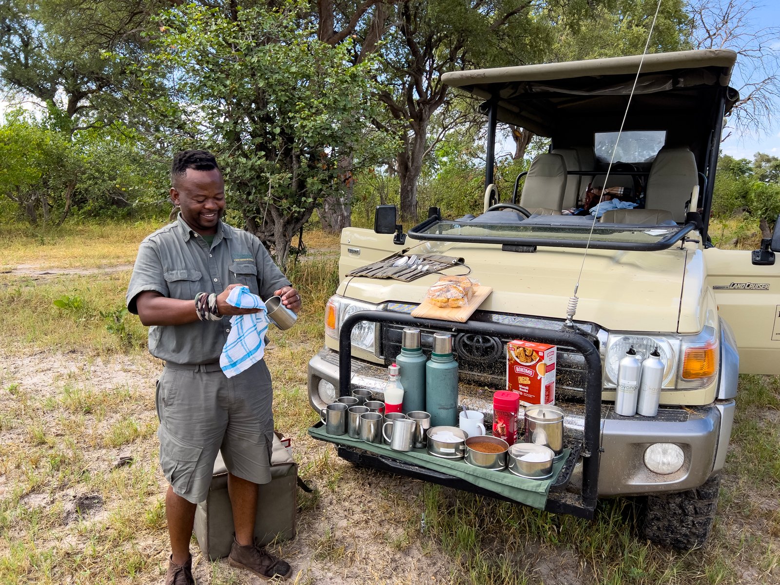 Okavango Expeditions Guide am Morgenkaffee zubereiten beim Landcruiser Fahrzeug