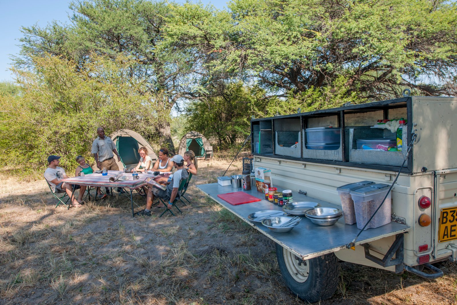 Bush Ways Fahrzeug mit Küche und Teilnehmer mit Guide am Tisch