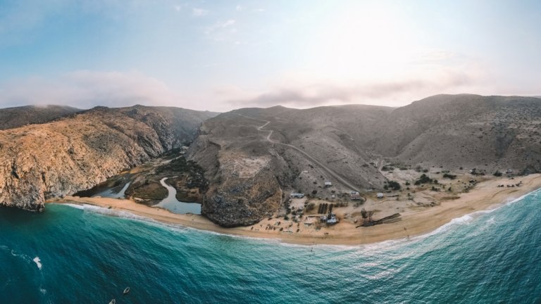 Meer mit Strand und Hügel im Hintergrund