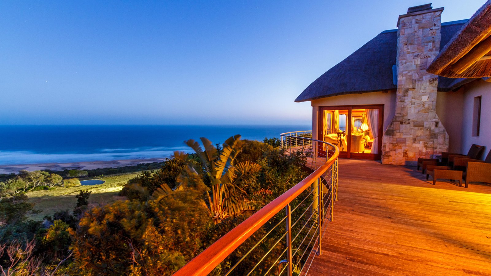 Zimmerterrasse mit Blick auf den Strand und Meer am Abend