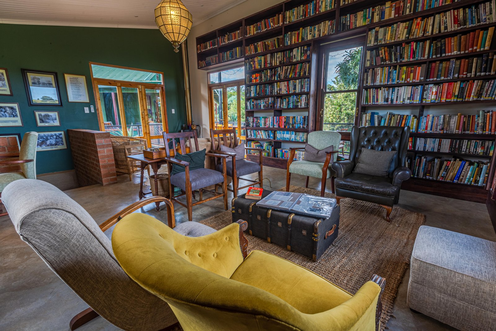 Wohnbereich mit Sessel und grossem Bücherregal