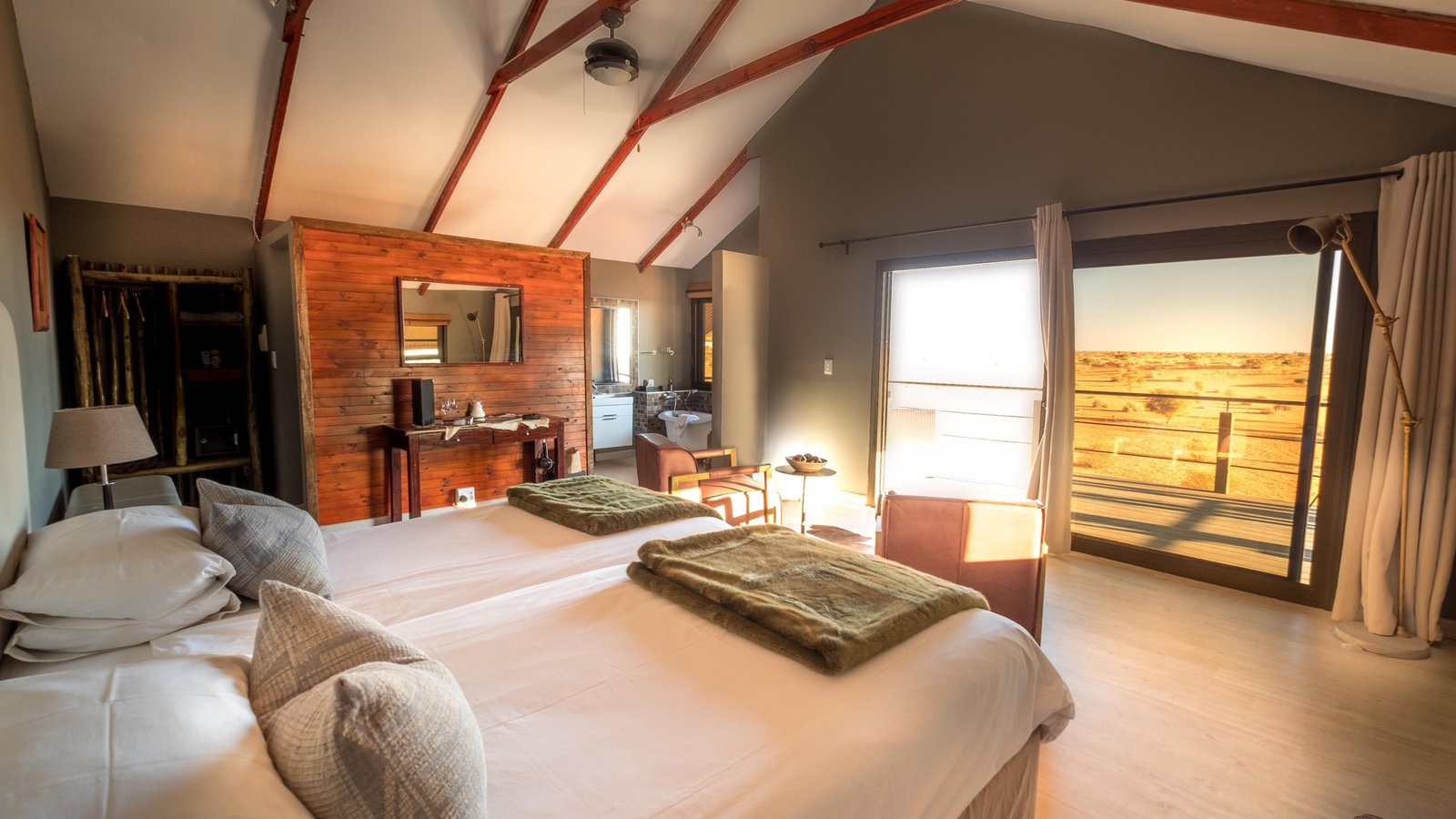 Schlafzimmer mit Bett und Aussicht auf die Terrasse und die Kalahari