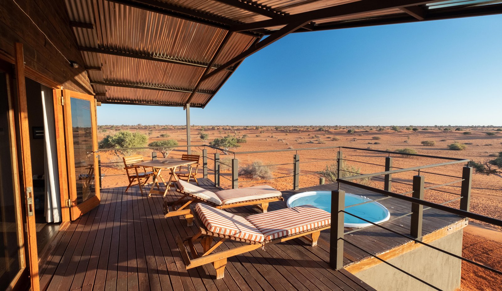 Privater Plungepool auf der Terrasse mit Liegestühlen und Blick in die Kalahari