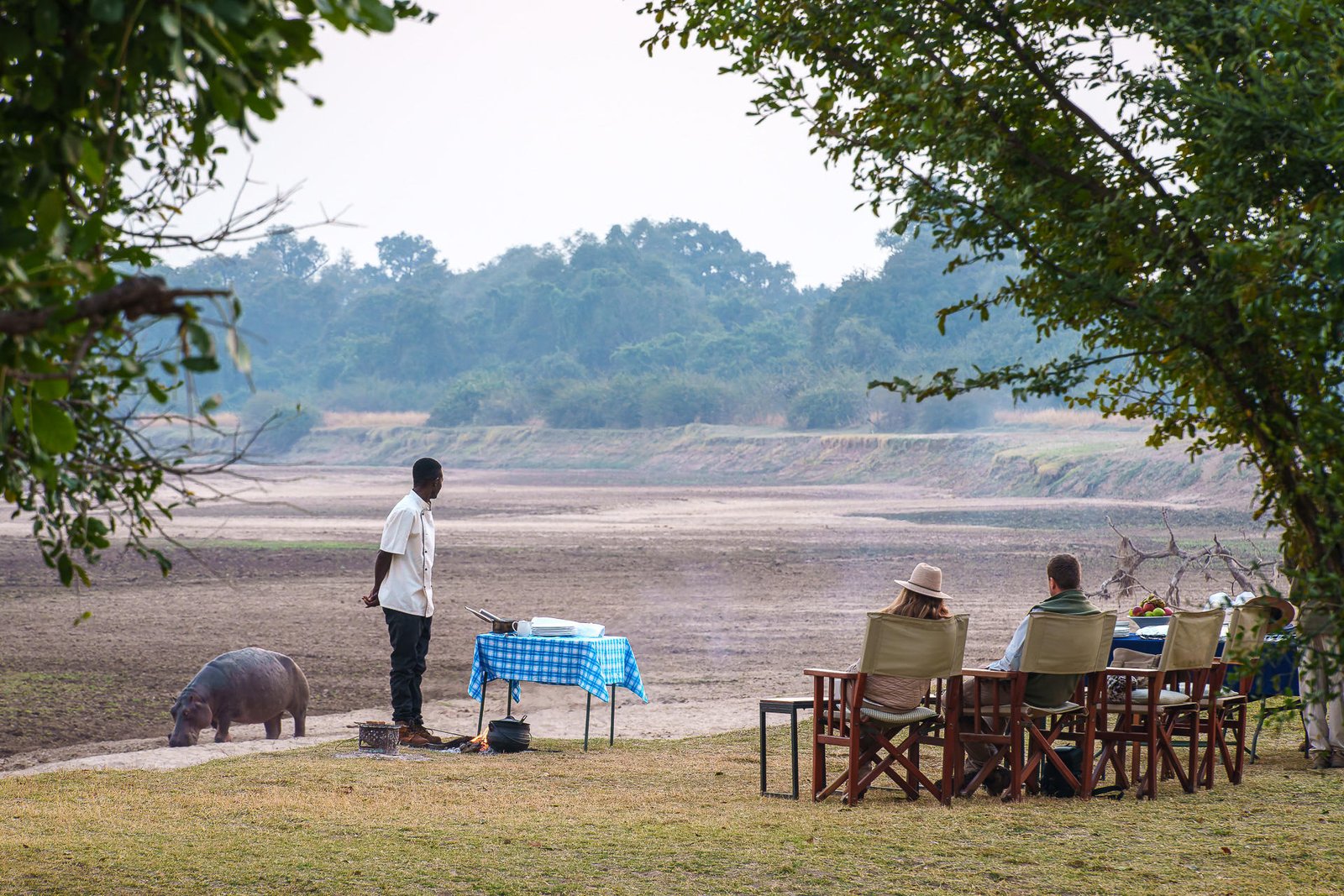 Sundowner am Luangwa River mit Flusspferd im Hintergrund