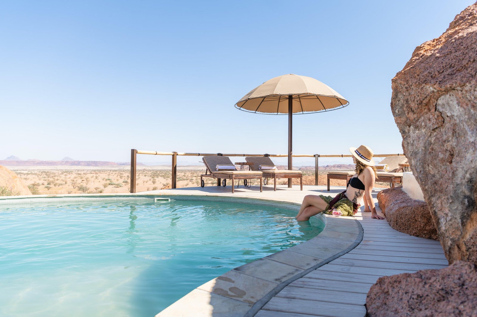 Swimmingpool mit Liegestühlen und schöne Aussicht in Wüstenlandschaft