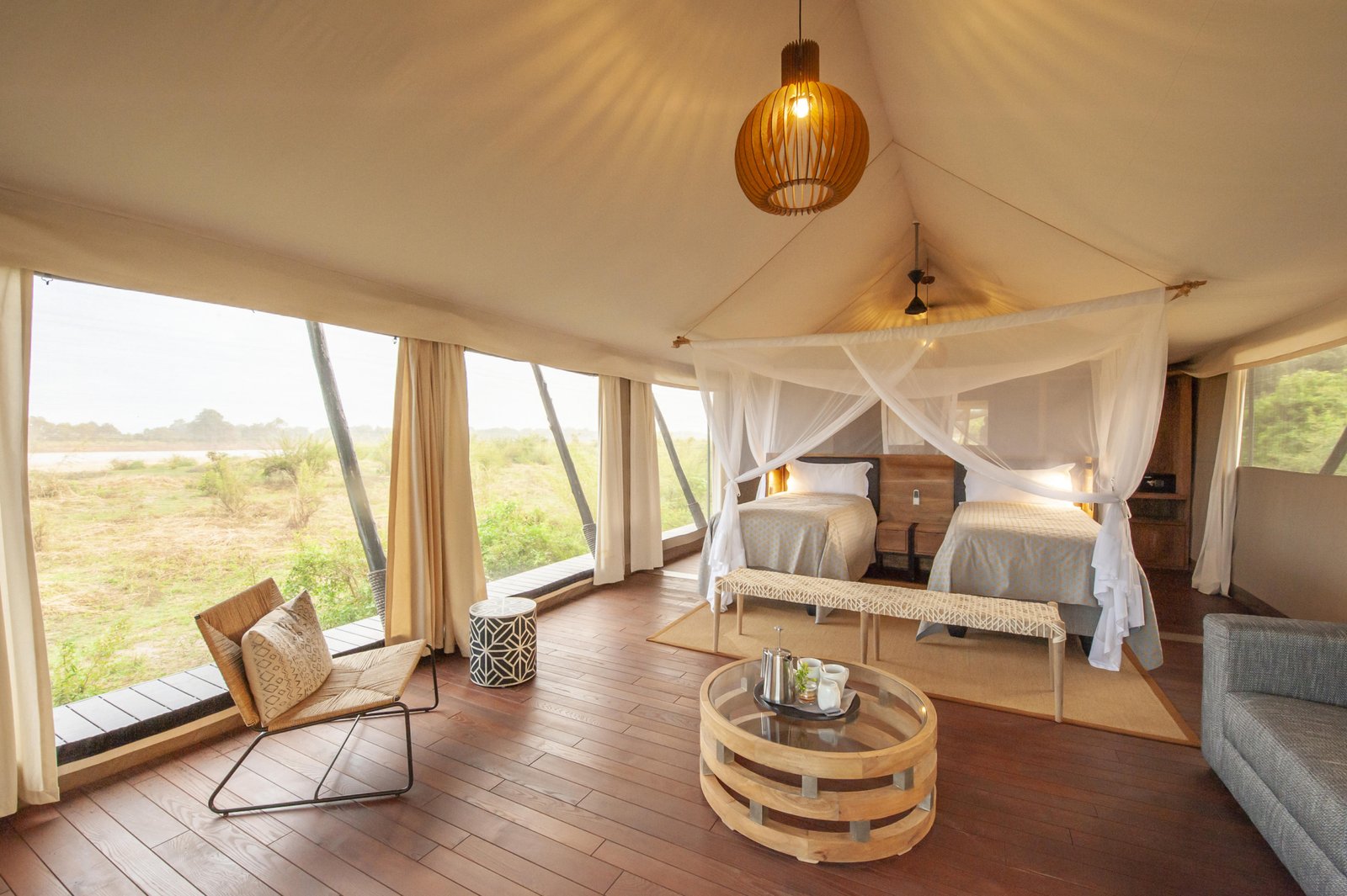 Chikunto Safari Lodge Safari Zelt mit Betten und Lounge sowie Sicht in die Natur