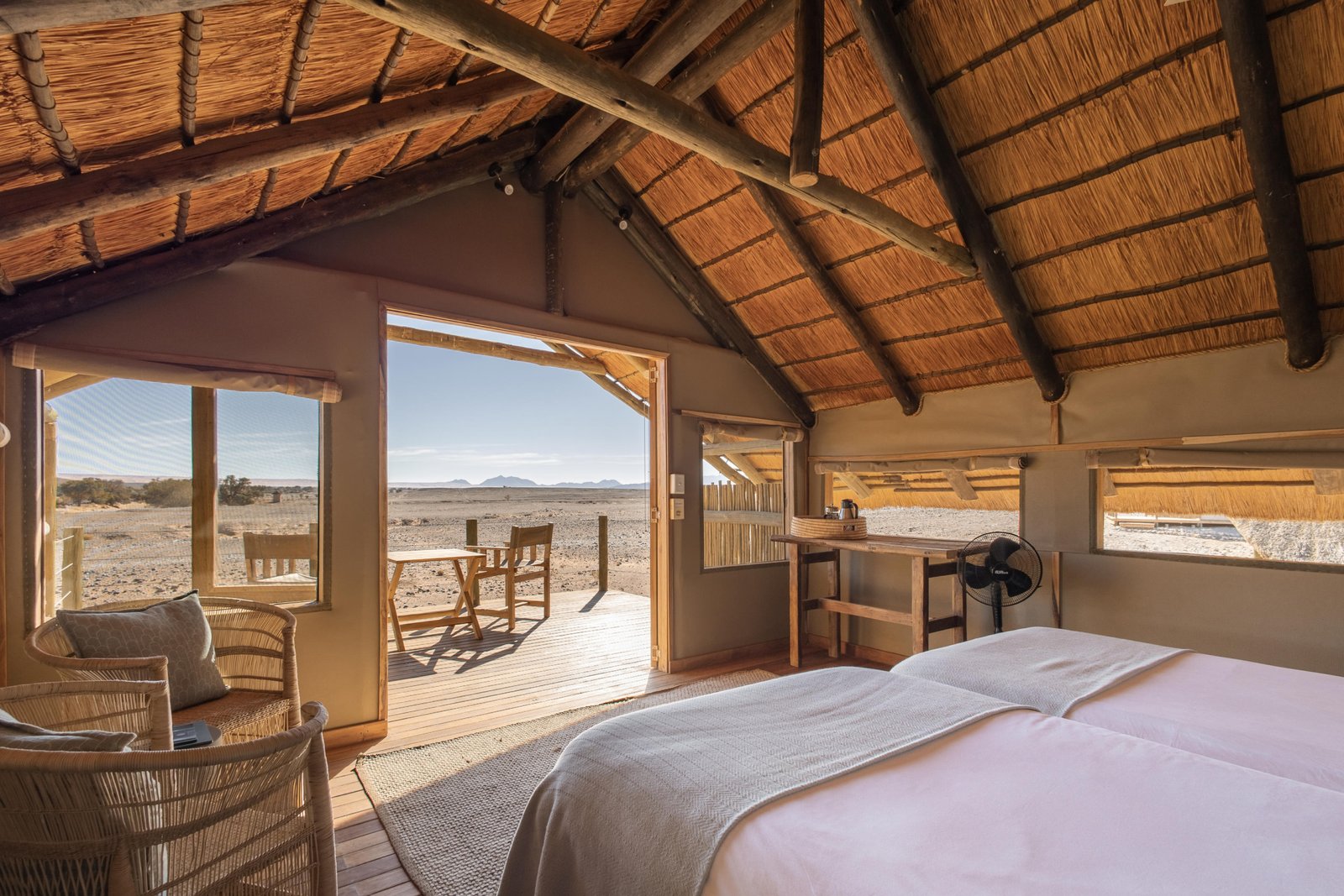 Schlafzimmer mit Bett und Blick auf Terrasse und auf die Landschaft