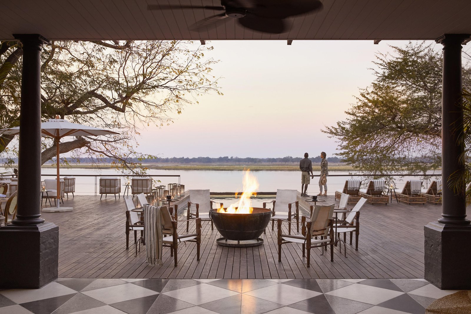 Der Hauptbereich des Zambezi Grande mit Feuerstelle, gemütlichen Sitzgelegenheiten und Blick auf den Fluss.