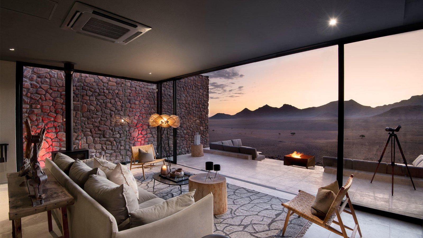 Wohnbereich mit Blick auf Terrasse, Feuerstelle und Wüstenlandschaft