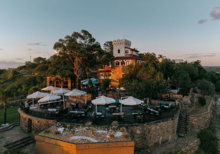 Heinitzburg mit historischem Burgturm und Terrasse mit Tischen