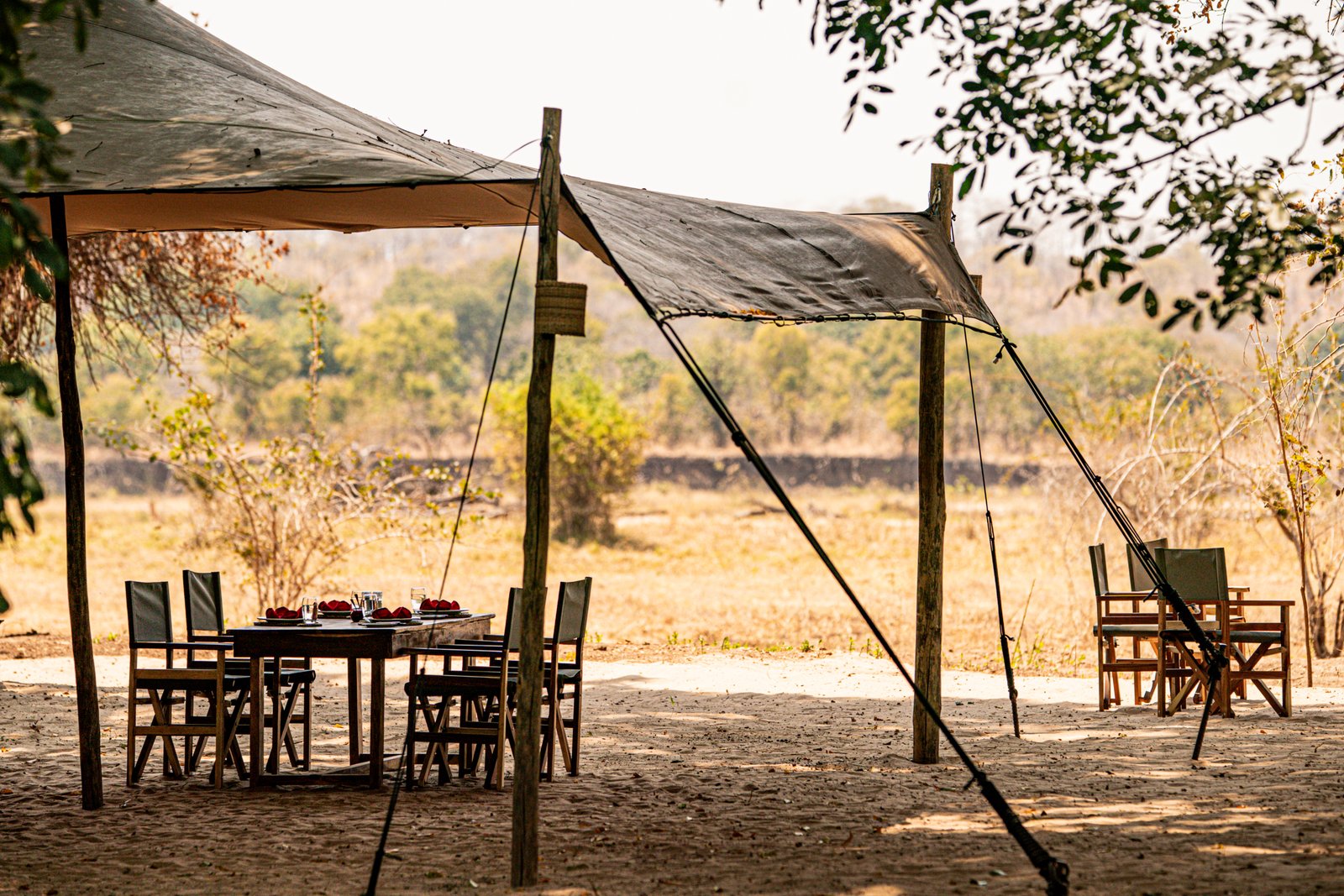 Kutandala Camp North Luangwa Nationalpark Hauptbereich mit Tisch und Stühlen unter dem Zeltdach