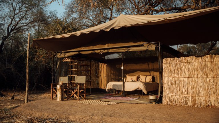 Kutandala Camp North Luangwa Nationalpark Zeltzimmer mit Bett und Stühlen