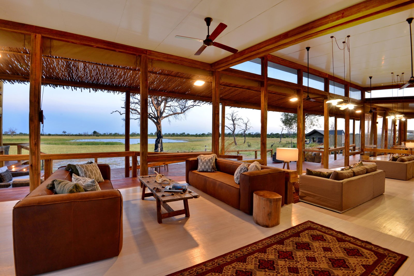 Loungebereich in der Hauptlodge mit Blick auf das Wasserloch und den umliegenden Busch