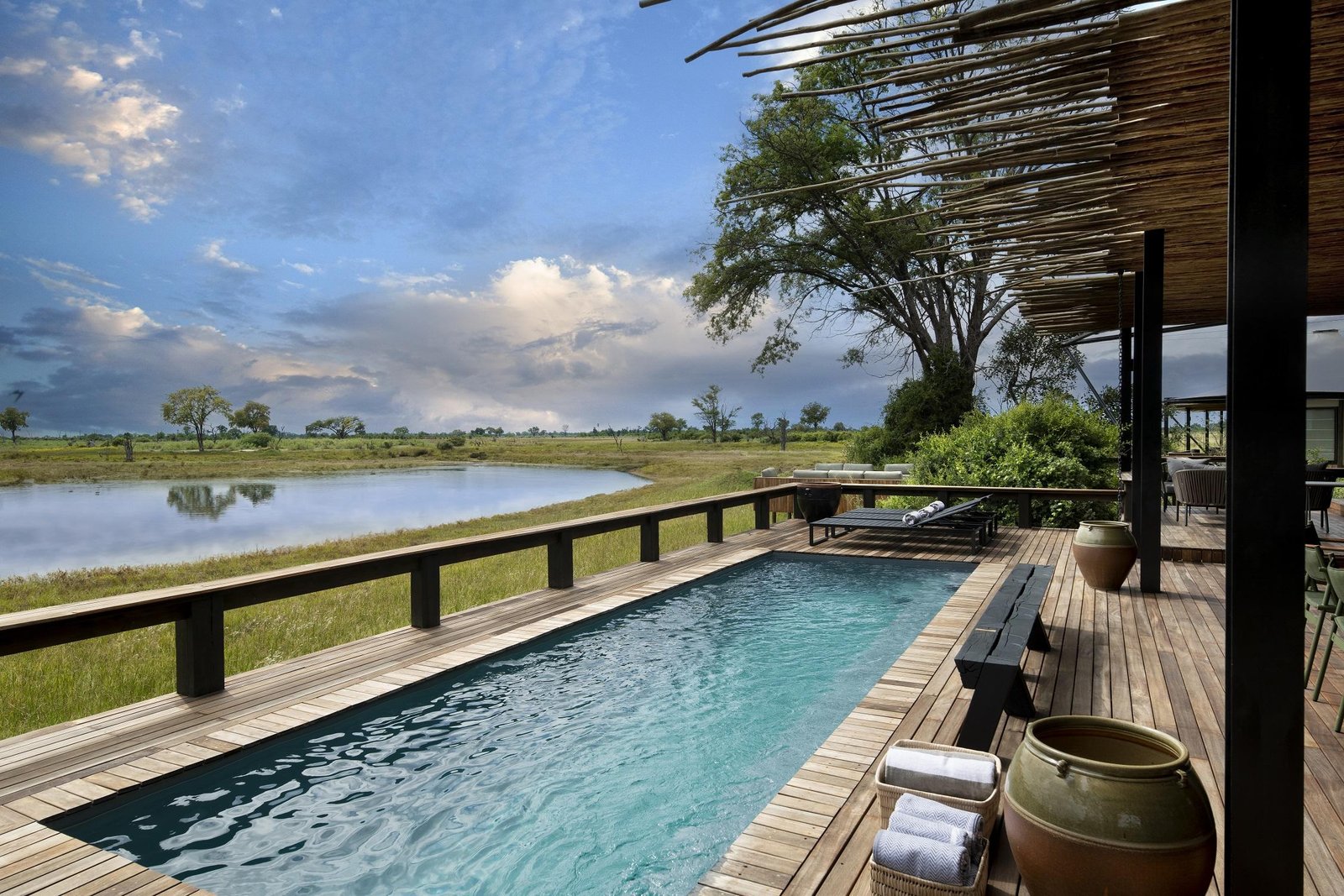 Swimmingpool mit Liegen und Blick auf das Wasserloch