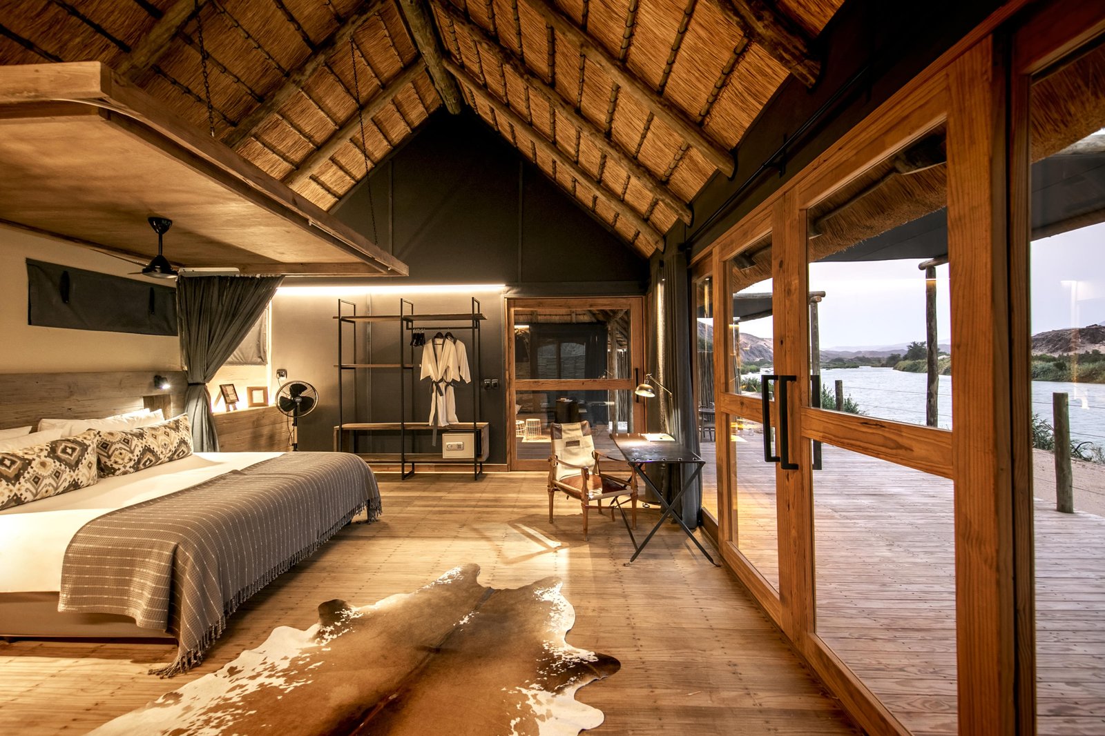 Schlafzimmer mit gemütlichem Bett, privater Terrasse und Blick auf den Kununen River
