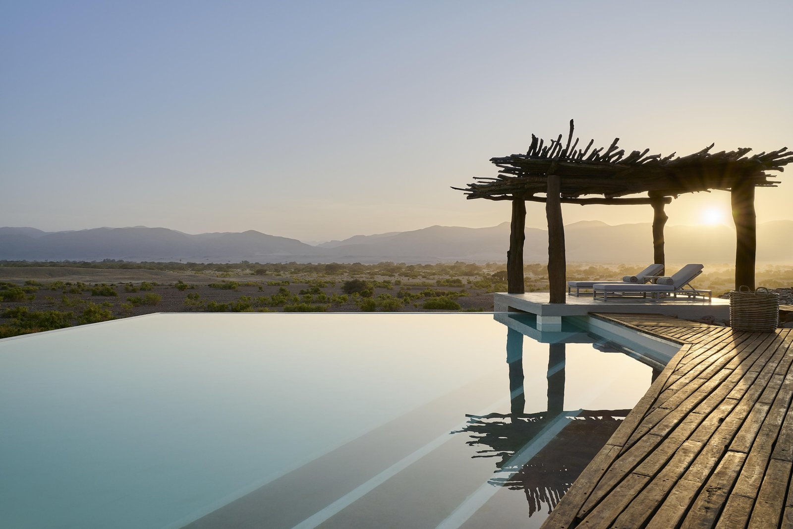 Swimmingpool mit gemütlichen Liegen und Blick in die Natur