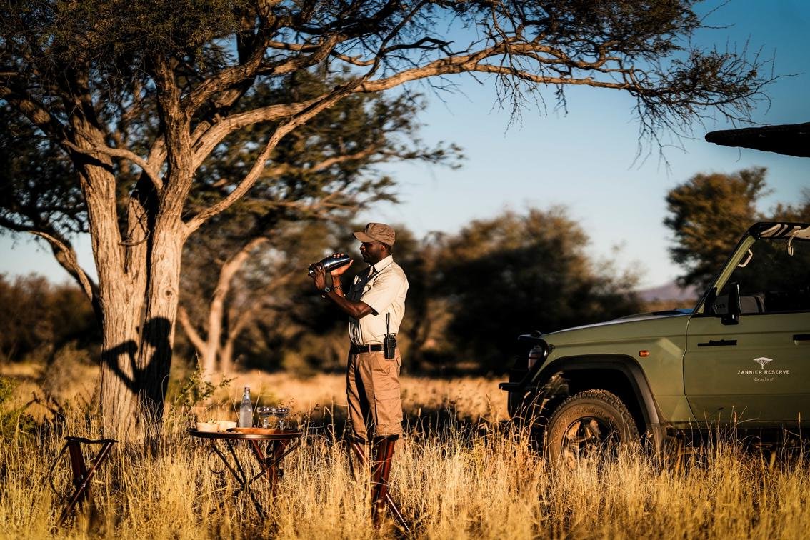 Safari-Guide bereitet Drinks für den Sundowner zu